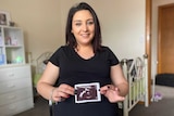 a pregnant woman holding an ultrasound