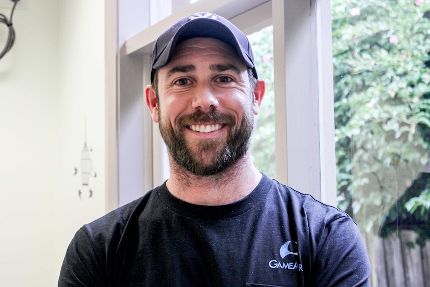 Andrew Kinch smiling and wearing a baseball cap.