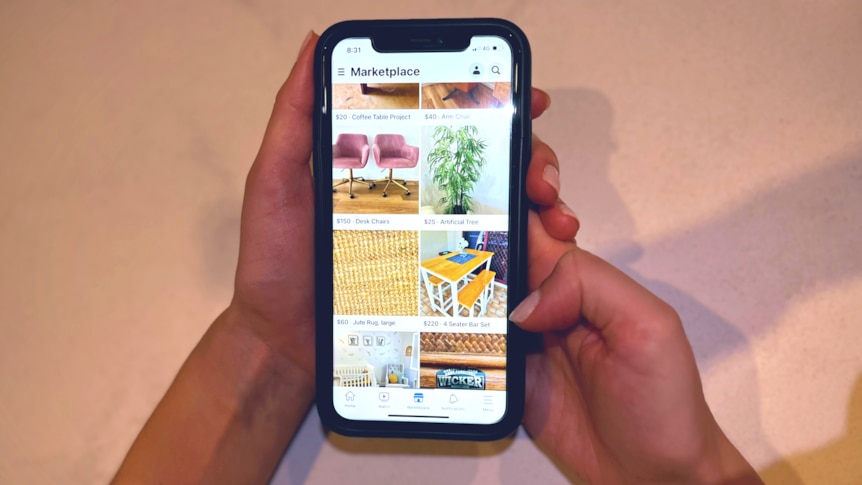 Hands hold a mobile phone with Facebook Marketplace open in screen
