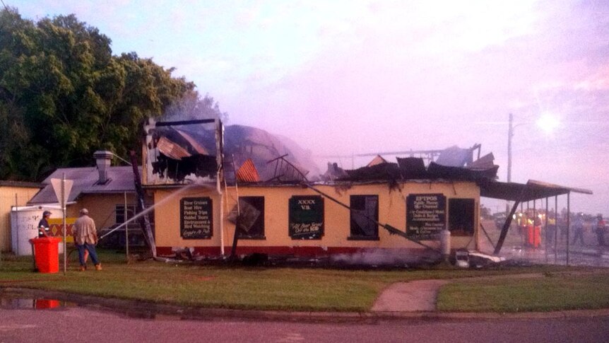 The remains of the Burketown pub are hosed down after it was gutted by fire.