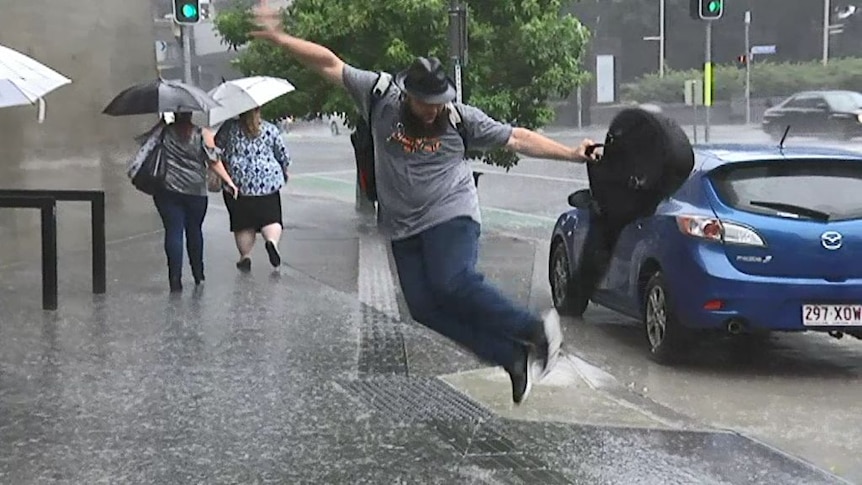 Man jumps for joy in the Brisbane rain