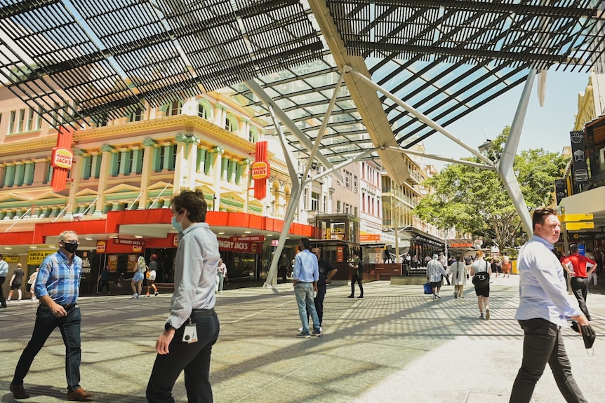 People cross queen st mall.