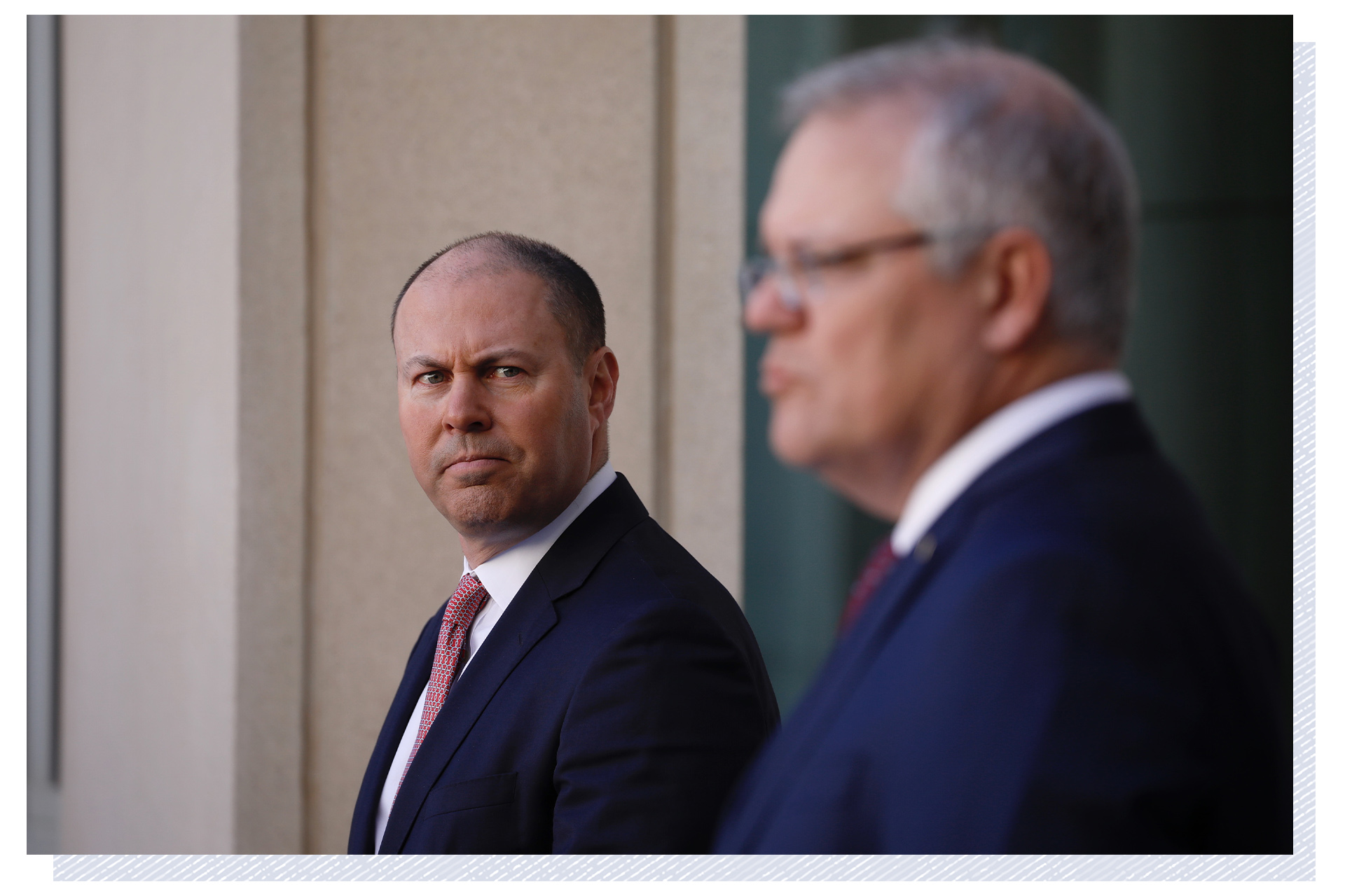 Josh Frydenberg looks across to Scott Morrison as they give a press conference in the Prime Minister's courtyard.