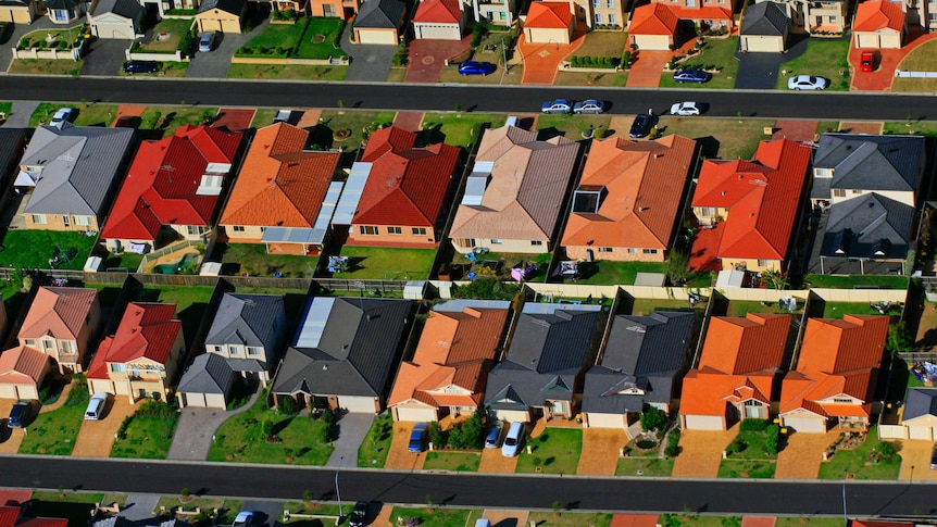 An aerial shot of rows and rows of houses in a suburban block.