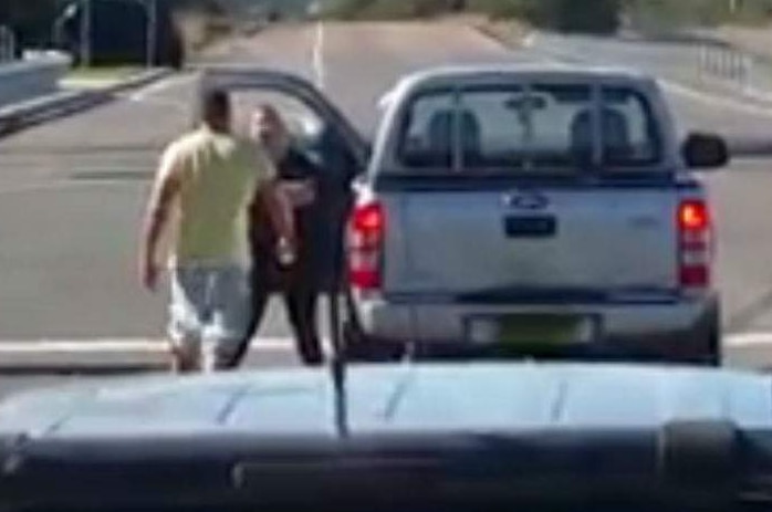 A man and a woman stand next to a car.