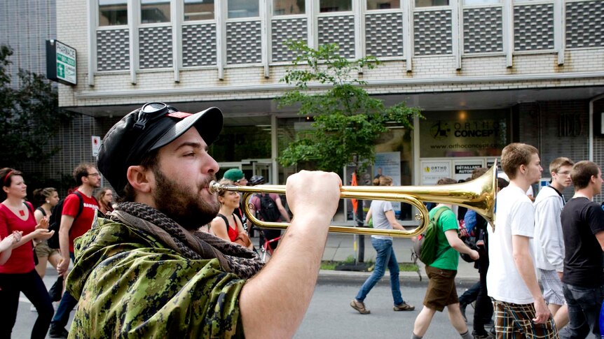 A protester blows a horn