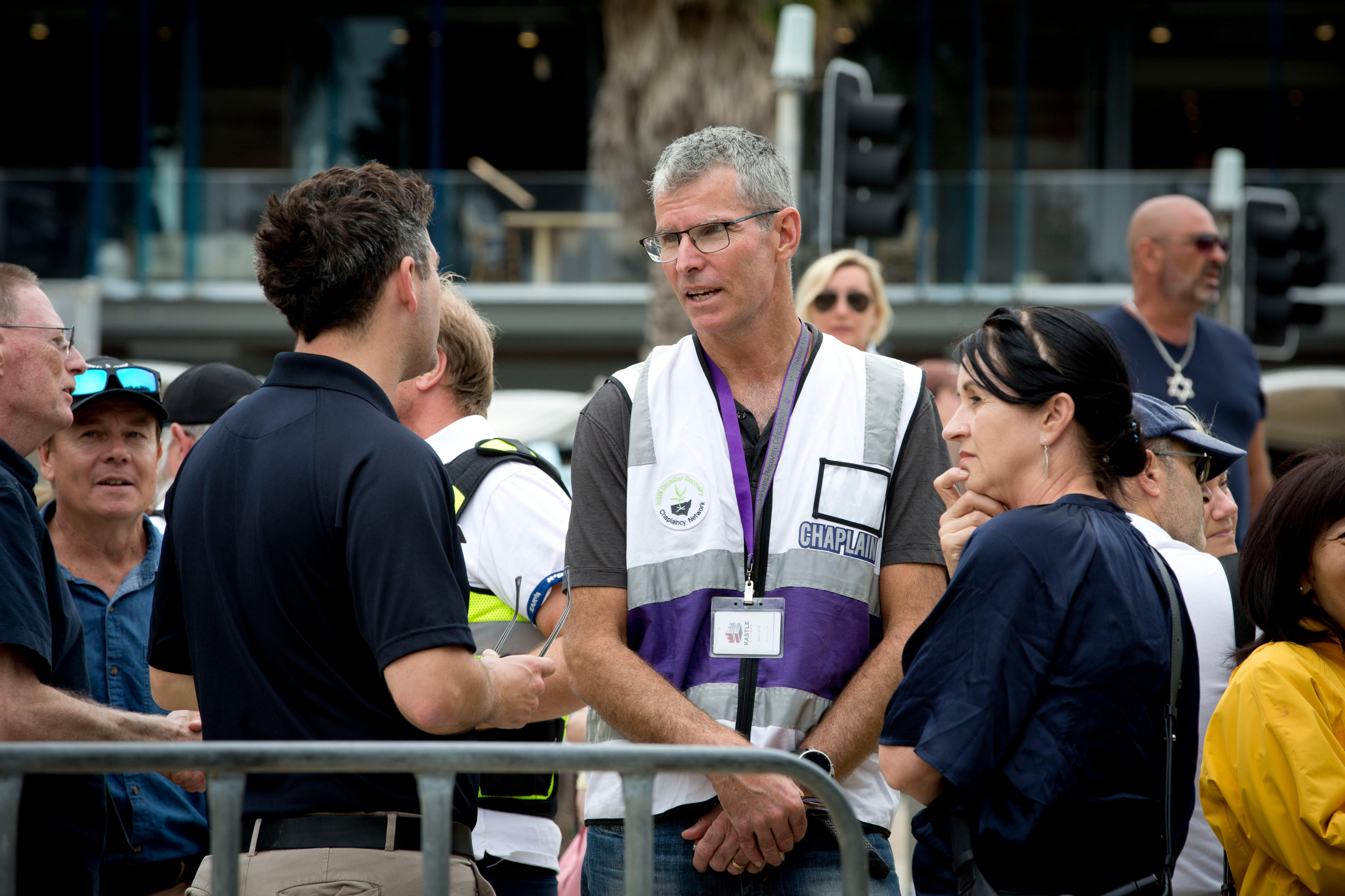 Um reverendo fala com um homem e uma mulher do lado de fora