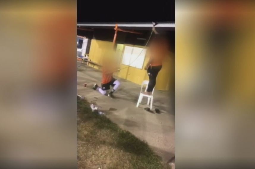 Members of the Canberra Cavalry baseball team egging a teammate on to scull a bear bong.