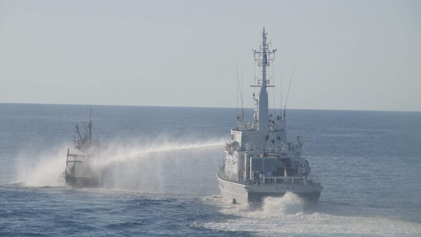Japan Coast Guard's water spray hits a fishing boat.