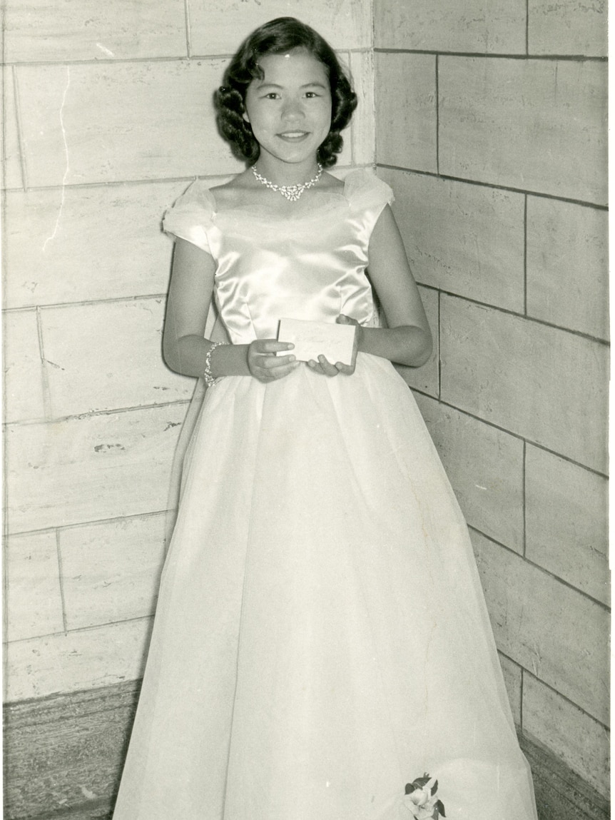 Black and white photo of a woman wearing a deb gown.