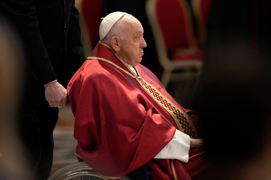 Pope sits in garb in wheelchair 
