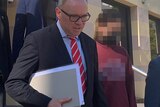 A girl with her face and jumper pixellated to disguise her identity walks out of court in Perth flanked by two lawyers.