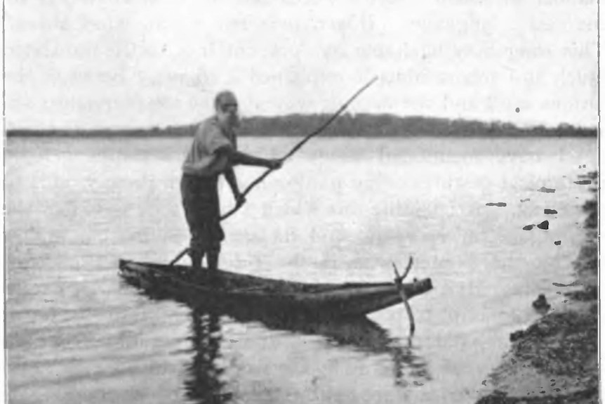 Black and white photo of a man on a bark canoe