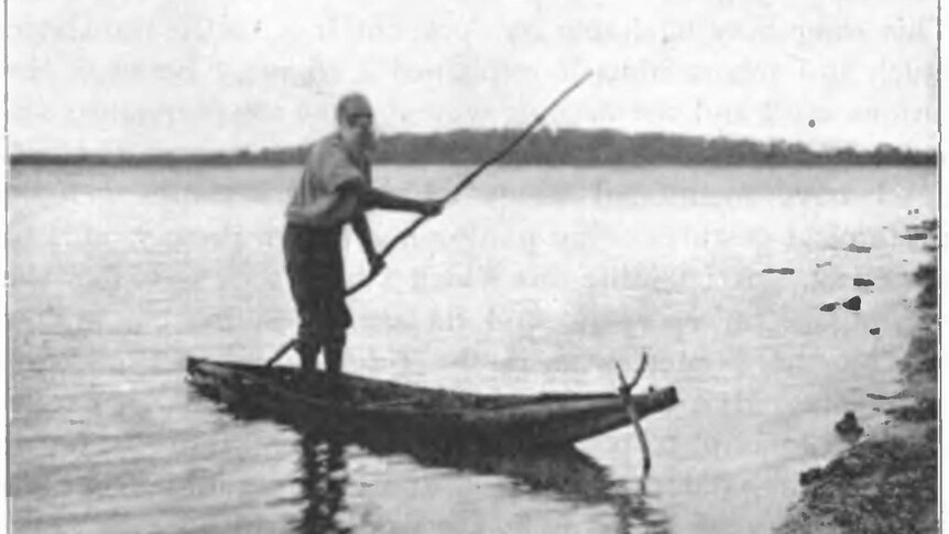 Black and white photo of a man on a bark canoe