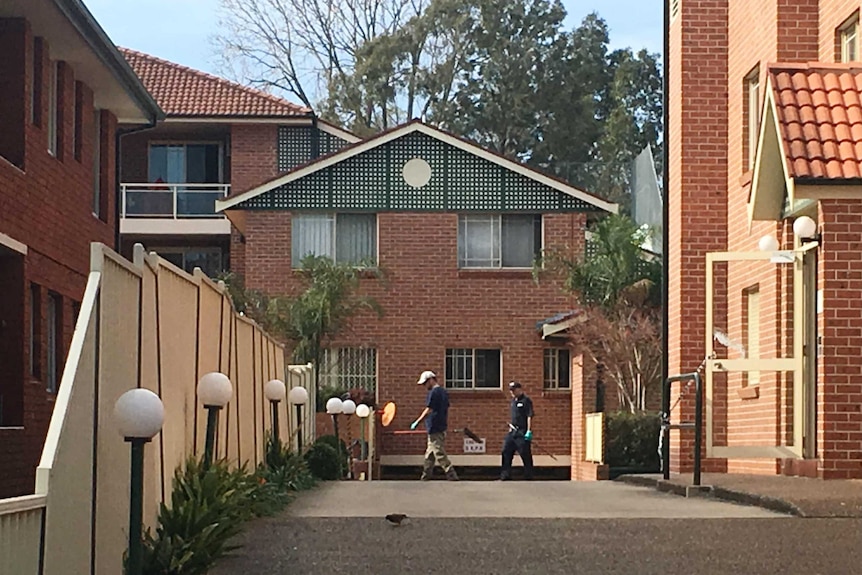 Forensic police dig in a garden bed at a unit block on Sproule Street at Lakemba on Sunday July 30 2017.