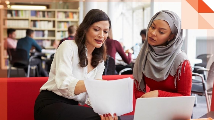 A woman helps another woman fill out forms.