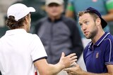 Two professional male tennis players have a conversation after their match in Indian Wells.