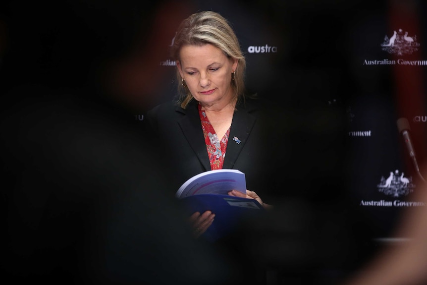 A woman looking through a report.