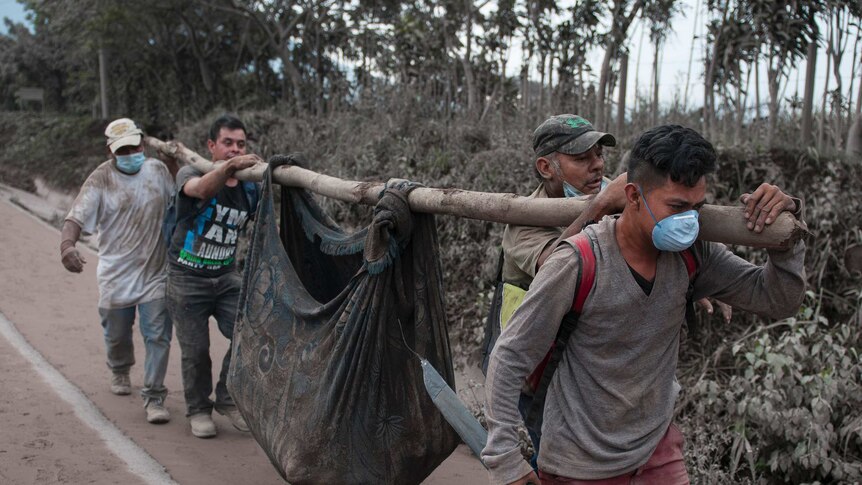 Residents carry a body recovered near the Volcan de Fuego