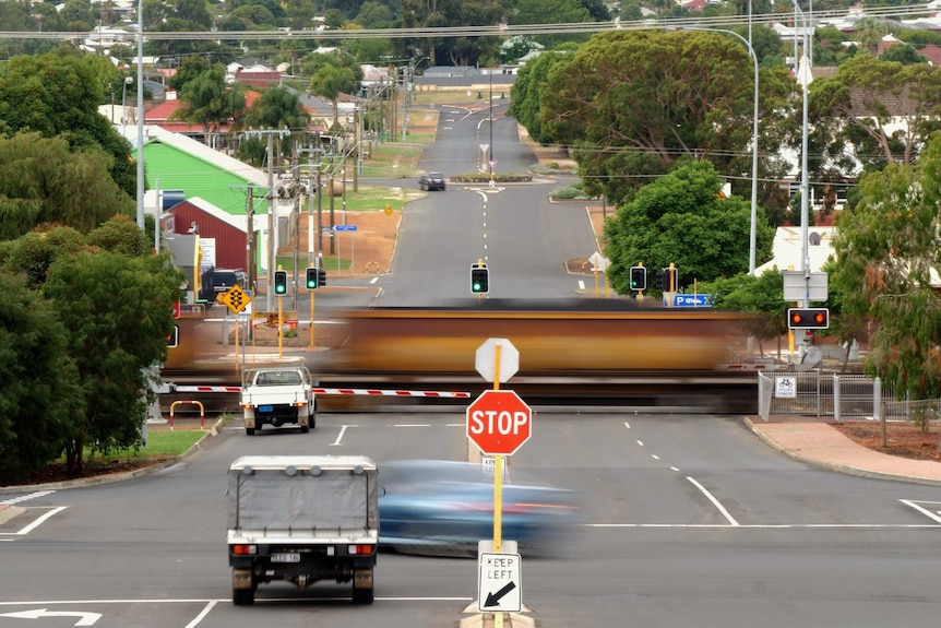 A train moves through the town of Collie