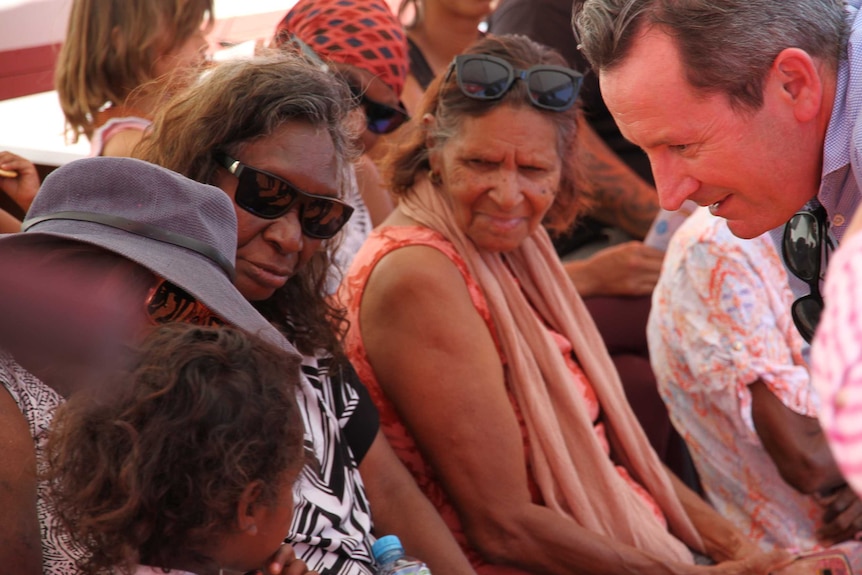 Close up of faces, Mark McGowan speaking with Yindjibarndi women and a child