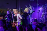 Drag queens and people dressed up as sequinned koalas performing in a crowded night club