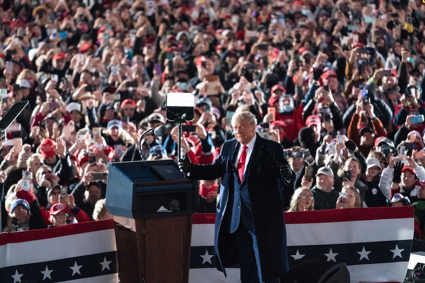 President Donald Trump stands at a podium in front of a big crowd at a US election rally in Pennsylvania.