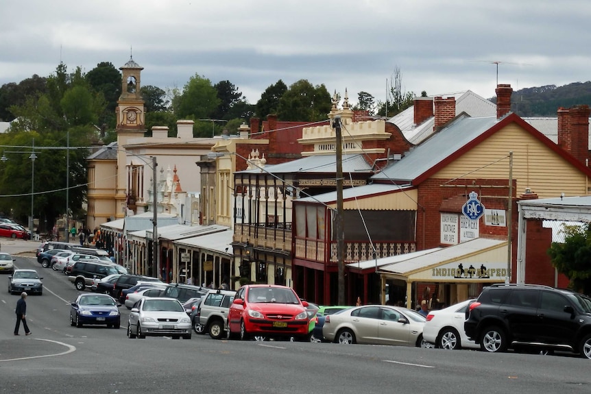 Looking down a country road with shops lining the street.