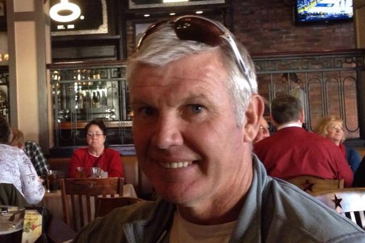 Danny Frawley smiles at the camera in a restaurant.