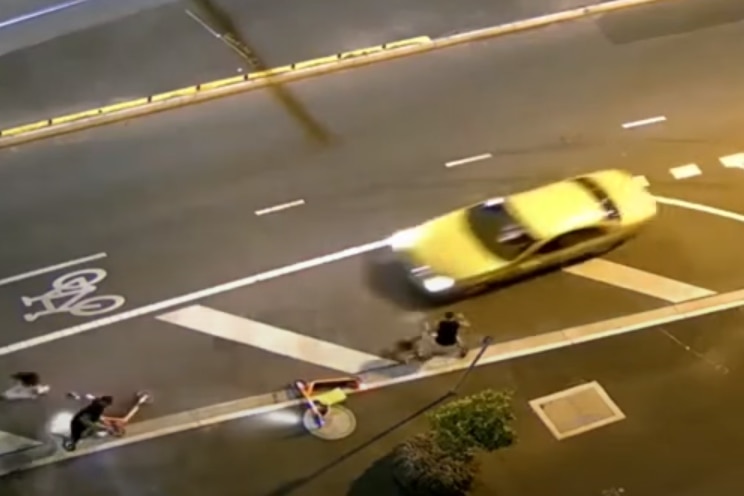 A yellow Ford automobile swerving towards pedestrians