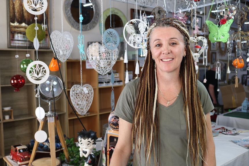 Woman with braided hair standing in a bric-a-brac shop.