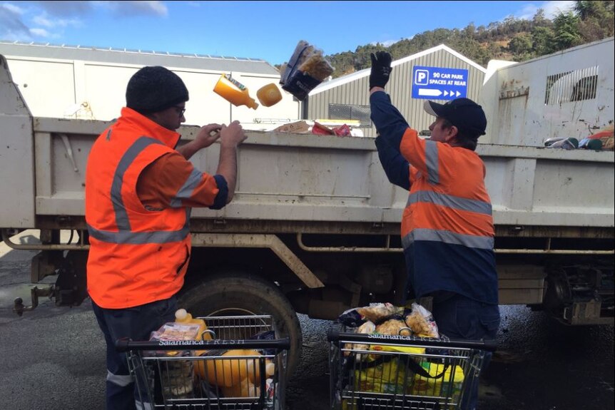 Workers throwing out flood-damaged food in Huonville