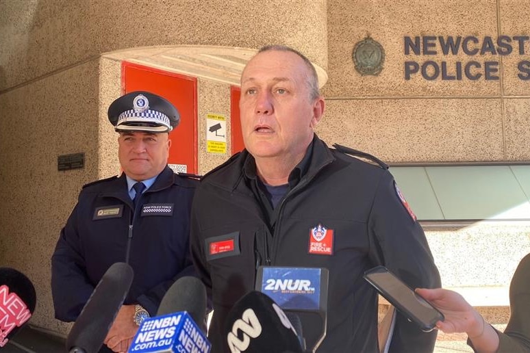 A police officer in uniform speaks to media