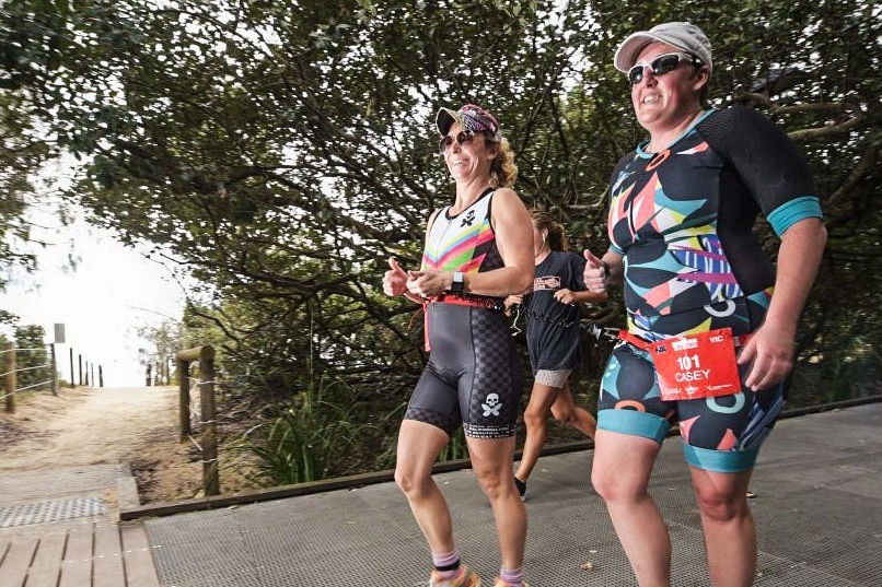 Two women tethered together, running