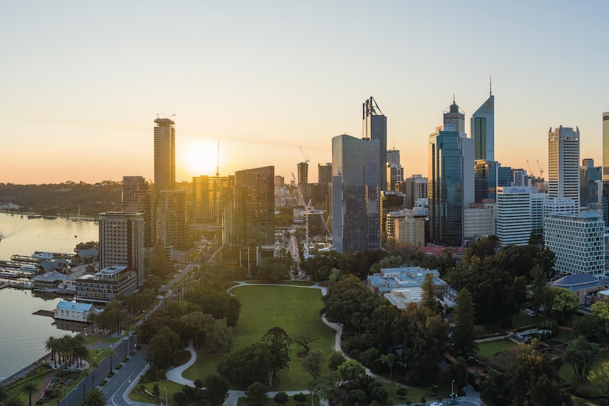 Skyline picture of Perth City at sunset, overlooking lush green gardens with skyscrapers in the background.