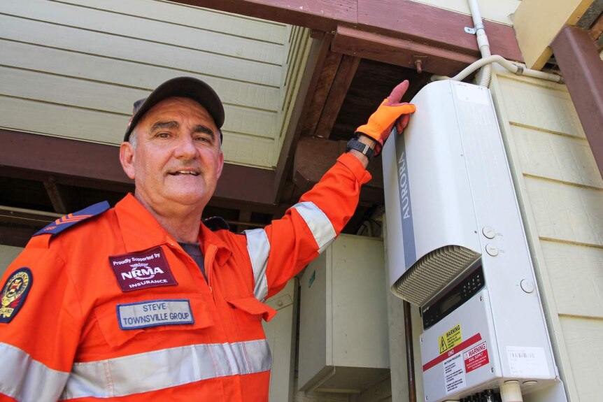 SES staff points at the cyclone bolts on an older style house