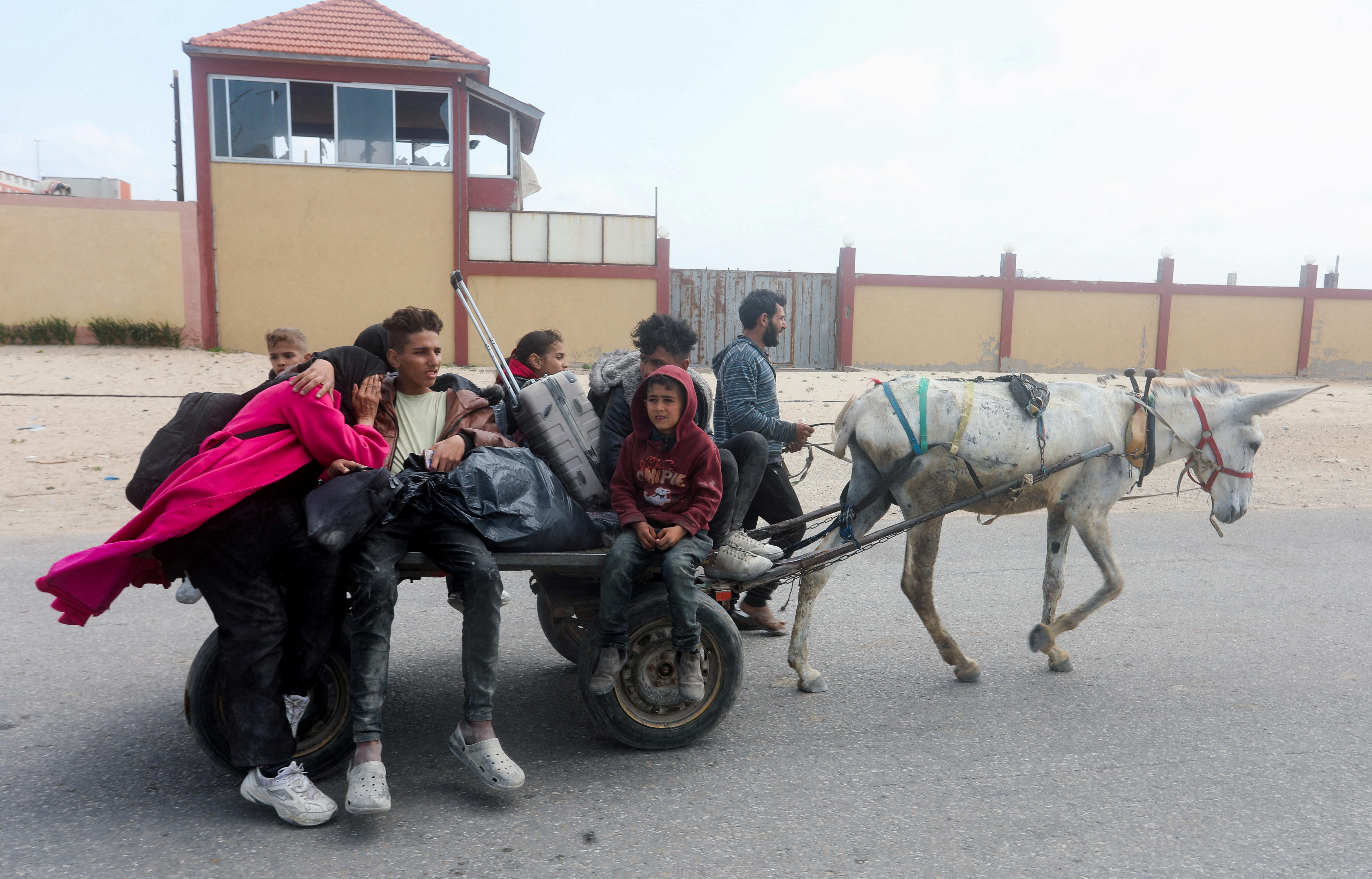 Family flees on a donkey and cart 