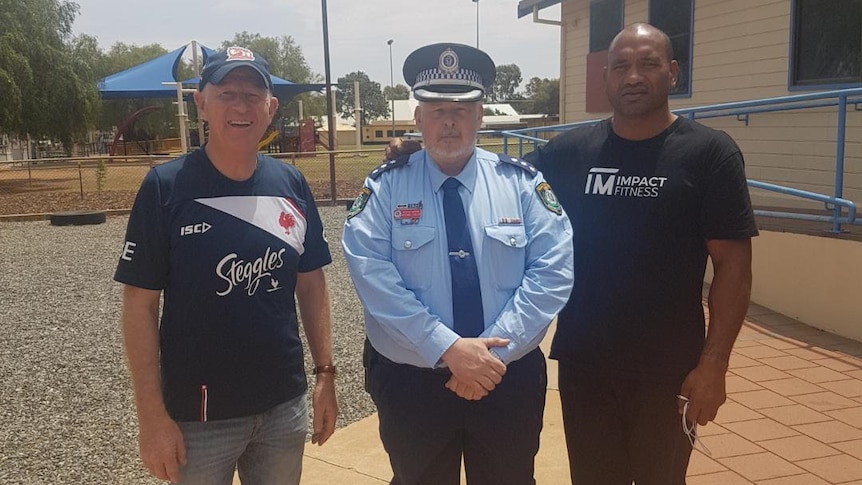 Detective Inspector, Michael Fuller, standing next to Solomon Haumono and Pastor Mark outside PCYC