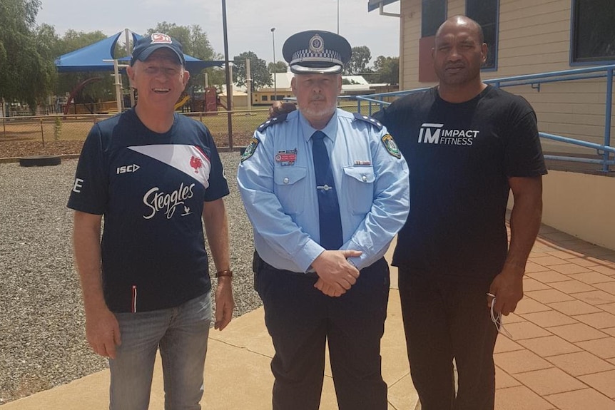 Detective Inspector, Michael Fuller, standing next to Solomon Haumono and Pastor Mark outside PCYC