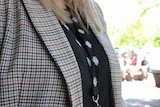 A photo of a womans chest with a black shirt and jacket