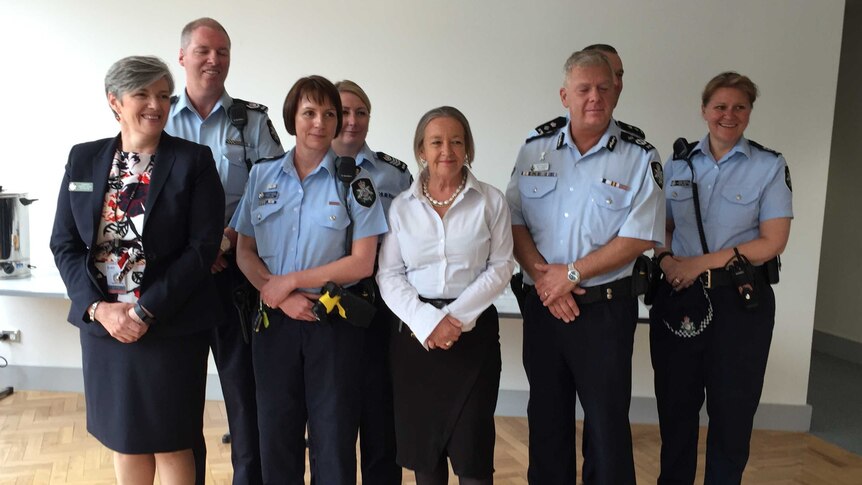 Police Minister Joy Burch and chief police officer Rudi Lammers pose with members of two new domestic violence teams
