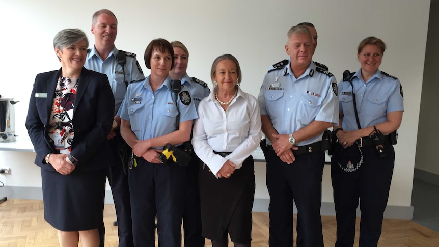 Police Minister Joy Burch and chief police officer Rudi Lammers pose with members of two new domestic violence teams