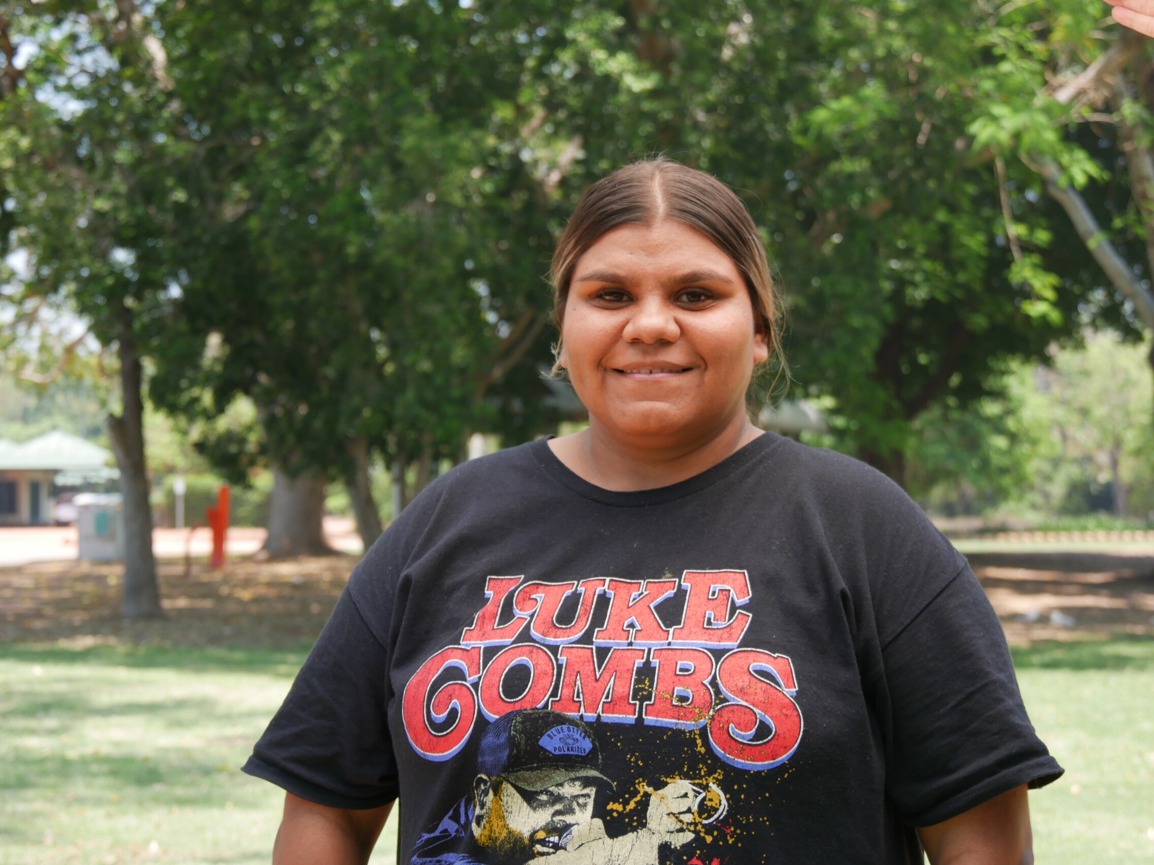 A woman with a black t-shirt looks at the camera