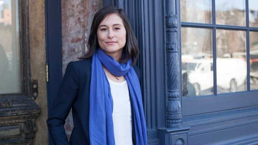 A woman in a blue scarf smiles