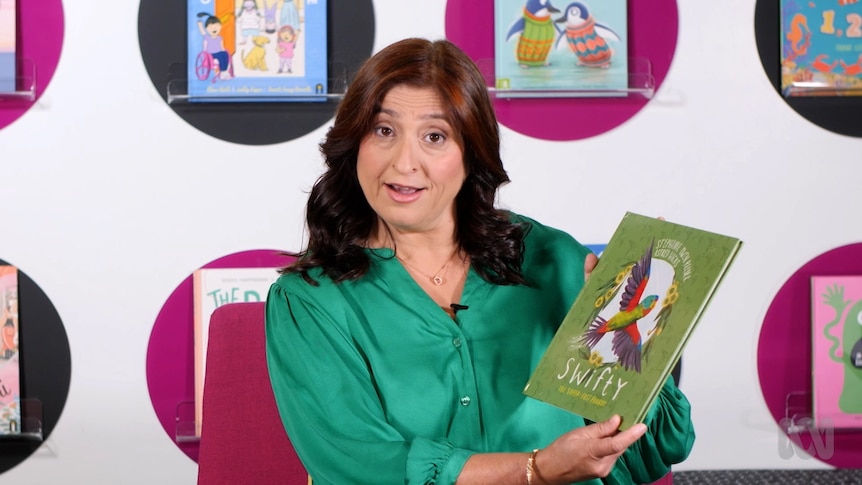 Teacher Dimple Bhardwaj holds up story book, Swifty: The Super-Fast Parrot