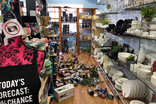 Bottles and other goods scattered over the floor of a kitchen shop.