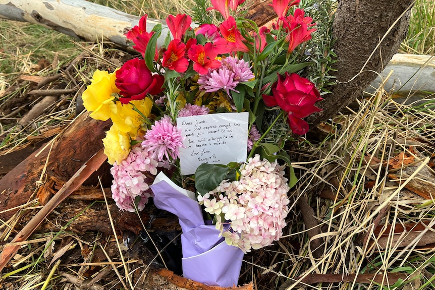 a bunch of flowers laid on a road as a tribute to victims of a fatal crash