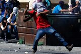 A Palestinian uses a sling to hurl a stone towards Israeli police during clashes in Shuafat, Jerusalem.