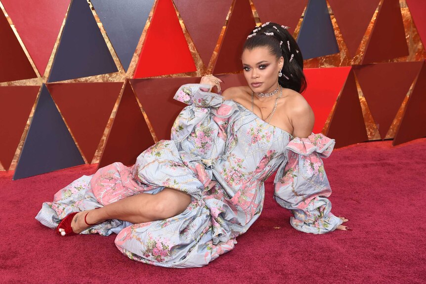 Singer Andra Day lays on the red carpet.