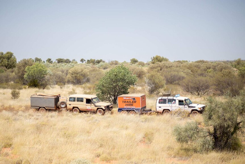 Two four wheel drives carrying musical gear through a very remote road in the desert.